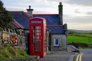 Red English telephone booth near a house