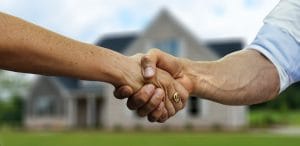 Handshake with a house in the background