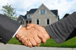 Handshake with a house in the background